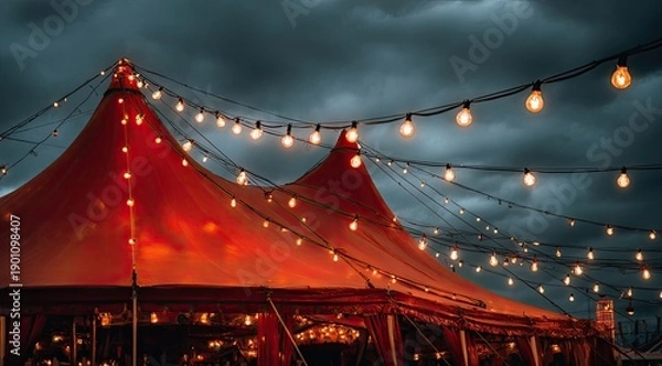 Obraz Glowing red tent under a dramatic, cloudy sky, illuminated by string lights