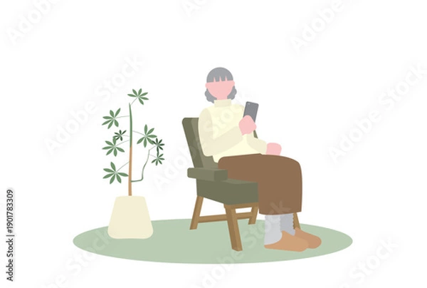 Obraz 一人がけソファに座ってスマホを見るシニア女性