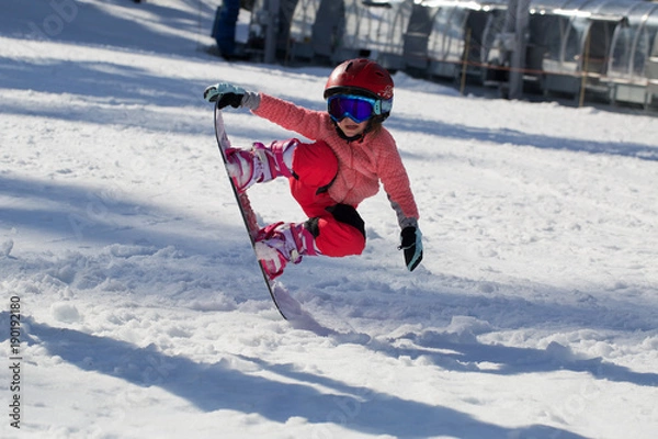Obraz Little Cute Girl Snowboarding  making a tricks at ski resort in sunny winter day. Caucasus Mountains. Mount Hood Meadows Oregon 