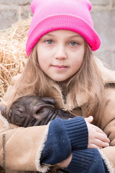 Fototapeta Adorable little childs in colorful clothers playing with just born piglets in winter fermers yard. Creative leisure with kids on swine farm