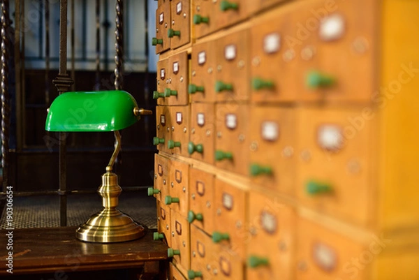 Obraz A library file with a desk and a lamp in the background.