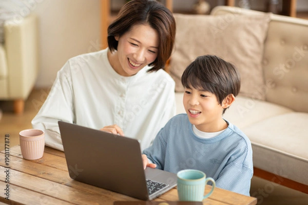 Obraz パソコンを見る男の子と横に座る母親