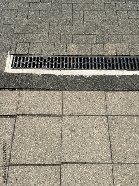 Obraz A drain on a sidewalk