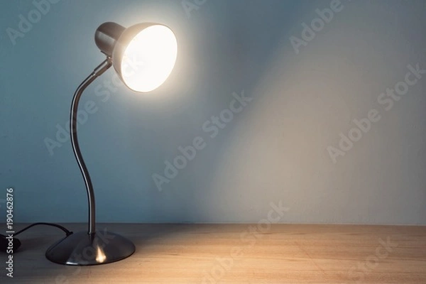 Fototapeta table lamp with light-on on the wooden table in vintage style.