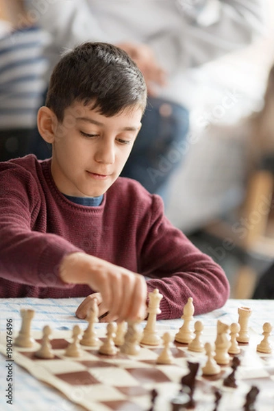 Fototapeta Young boy playing chess