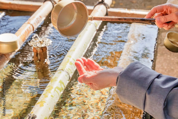 Obraz 神社の手水舎で手を清める様子