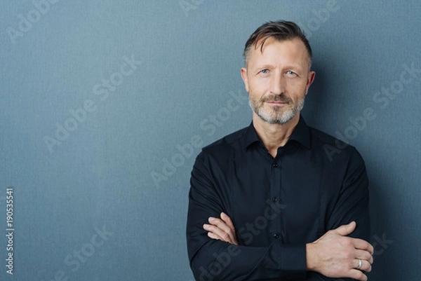 Obraz Poważny mężczyzna w średnim wieku z założonymi rękami
