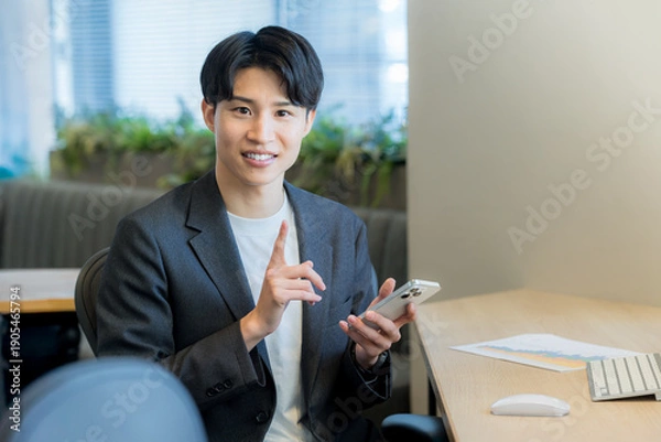 Obraz オフィスでスマホを使うビジネスマン