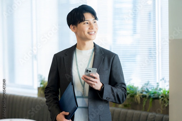 Obraz オフィスでスマホを使うビジネスマン