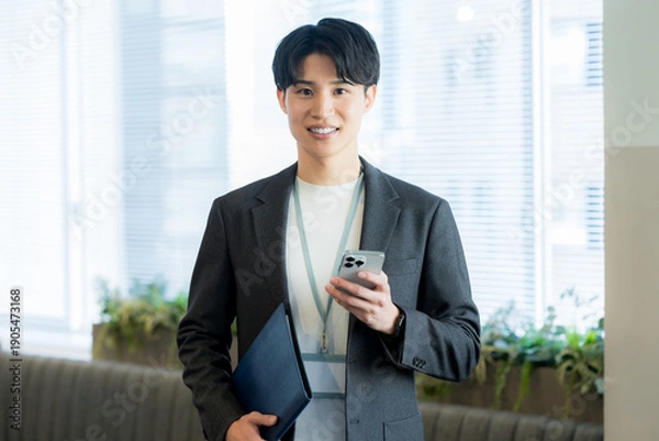 Obraz オフィスでスマホを使うビジネスマン