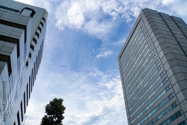 Obraz モダンな高層ビルに狭間から見上げる雲がかった青空