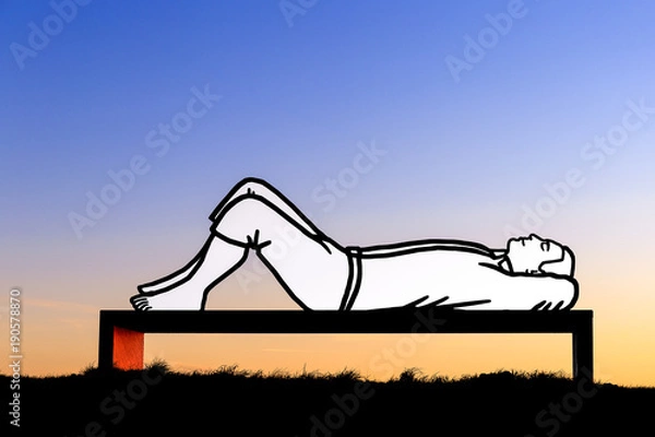 Fototapeta Lying man on a bench at sunset
