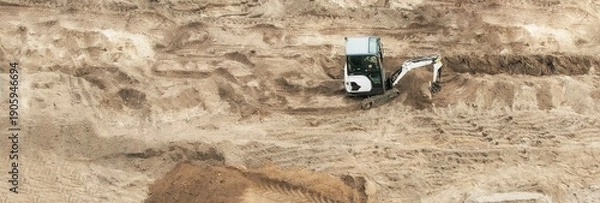 Obraz A small universal tractor is working at a construction site