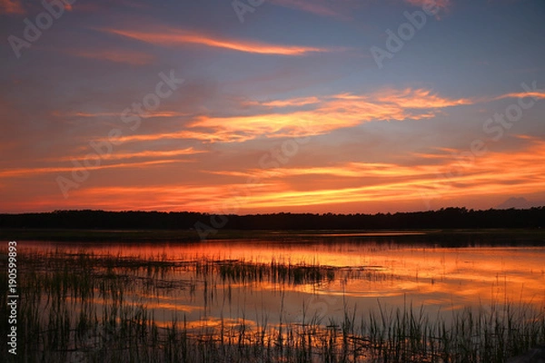 Fototapeta Huntington Beach State Park landscape.Dramatic sunset over the expansive salt marsh. Scenic view with amazing colors after sunset sky reflects in a calm water.Murrels Inlet,South Carolina,USA.