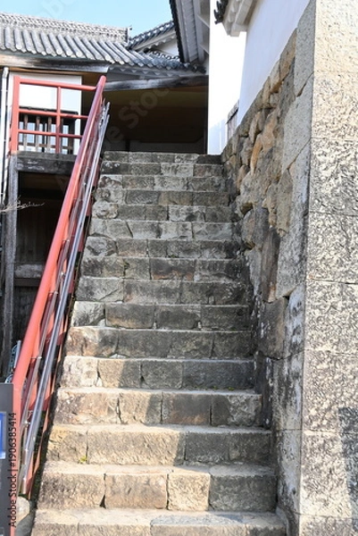Fototapeta 城郭の歴史を刻む石段：赤い手すりと古い石垣のコントラスト