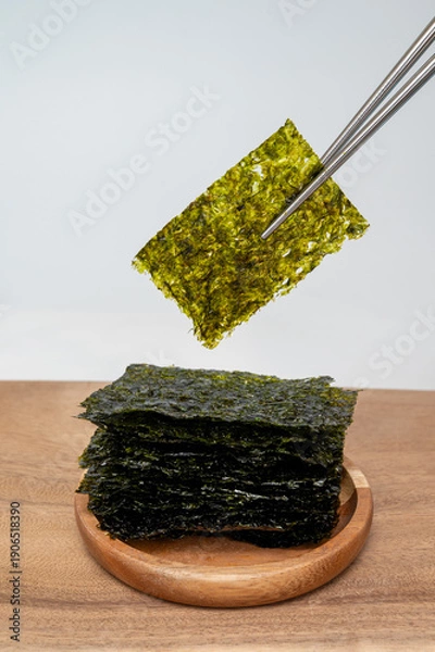 Obraz 흰 배경에 젓가락으로 잡고 있는 한국 전통 김