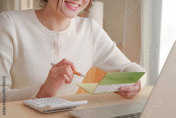 Obraz 通帳をみてお金の管理をする女性