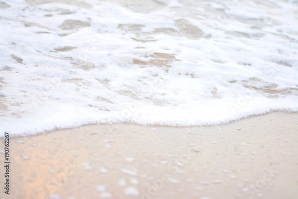 Fototapeta White waves blowing into the beach.