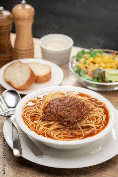 Obraz ミートソースのスープパスタとパンが並ぶランチテーブル