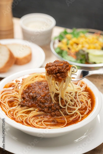 Obraz 伸びる麺をフォークで持ち上げたミートソースのスープパスタ