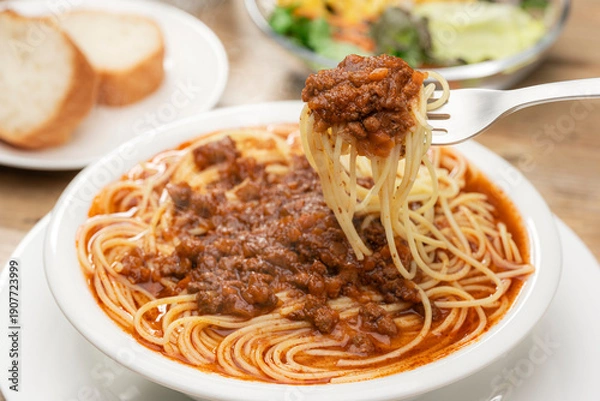 Obraz ミートソースのスープパスタをフォークで持ち上げる瞬間