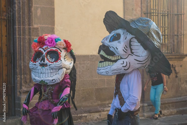Fototapeta Two people in celebratory costumes and masks for the Day of the Dead festivities, in San Miguel de Allende, Mexico