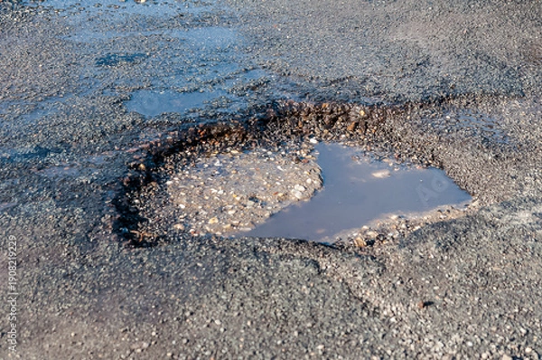 Fototapeta ein Schlagloch in einer Straße nach dem Winter