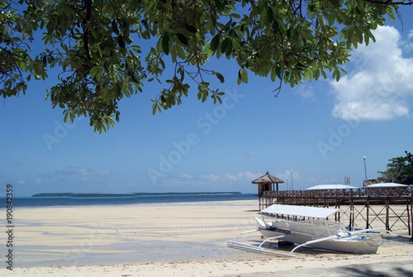 Fototapeta Seaside Scene with Outrigger and Boardwalk by a White Beach