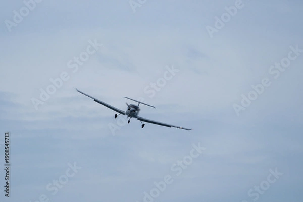 Obraz Single-engine plane approaching the airport under a cloudy sky