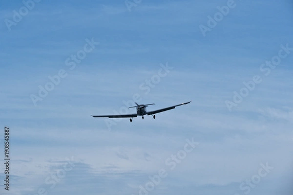 Obraz Single-engine plane approaching the airport under a cloudy sky