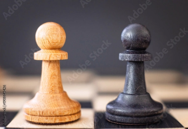 Obraz chess pieces on a chessboard on a dark background