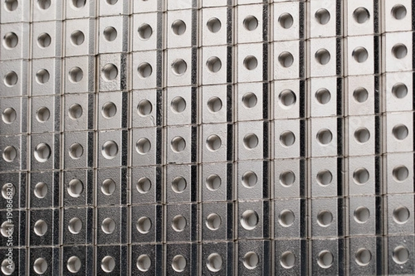 Fototapeta slide screw nuts in a row, abstract industrial background