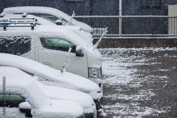 Obraz 雪の日に凍結防止でワイパーを立てて駐車された車列