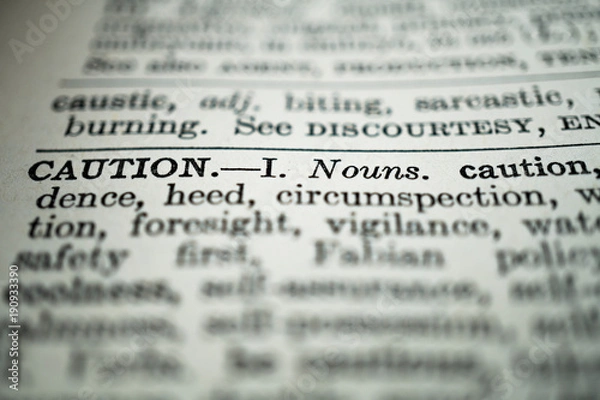 Obraz closeup of the word caution in the dictionary