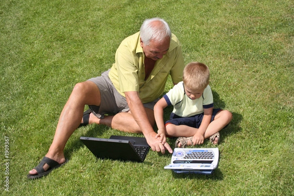 Obraz dziadek i wnuk pracujący nad laptopami