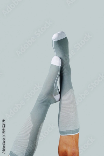 Obraz upside down man wearing gray compression socks