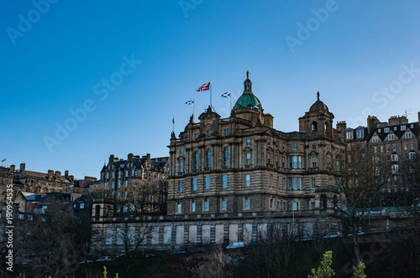 Fototapeta Scottish Saltire and British Union Jack flags on a top of a building of Lloyds Banking Group  in Edinburgh Scotland
