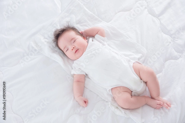Obraz Little asian infant sleeping on white bed in the morning