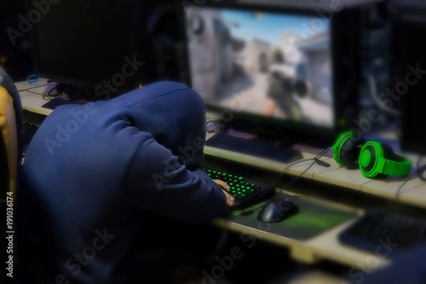 Fototapeta Tried gamer Sleeping in front of games monitor at internet cafe, game addiction concept, gamer lifestyle.