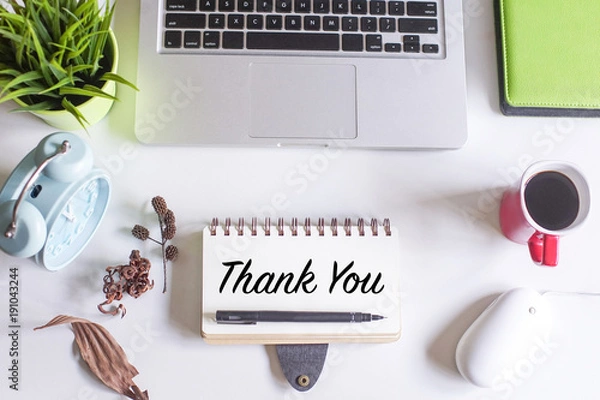 Fototapeta Thank You concept.Top view of white office desk with laptop,coffee,pen,magnifying glass,dried flowers and a note book Written with THANK YOU text.
