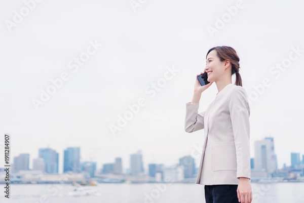 Obraz スマホで通話をするビジネスウーマン