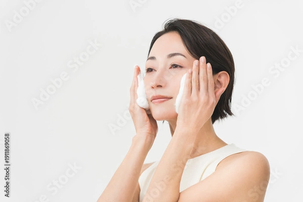 Obraz スキンケアプロセス。彼女は顔に泡をのせて洗顔をしている。