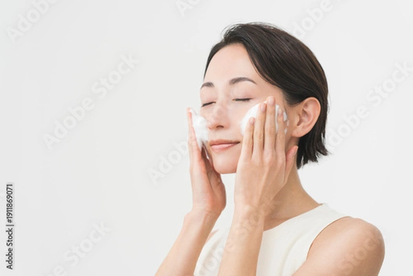 Obraz スキンケアプロセス。洗顔フォームの泡で洗顔をしている女性。