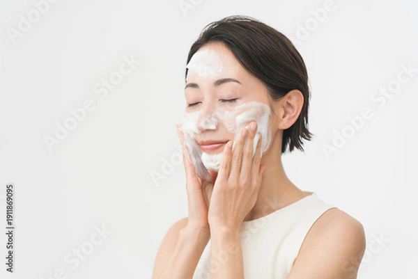Obraz スキンケアプロセス。洗顔フォームの泡で洗顔をしている女性。