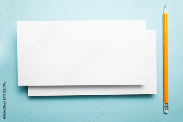 Fototapeta Blank layout of a greeting card on a blue background with a pencil.
