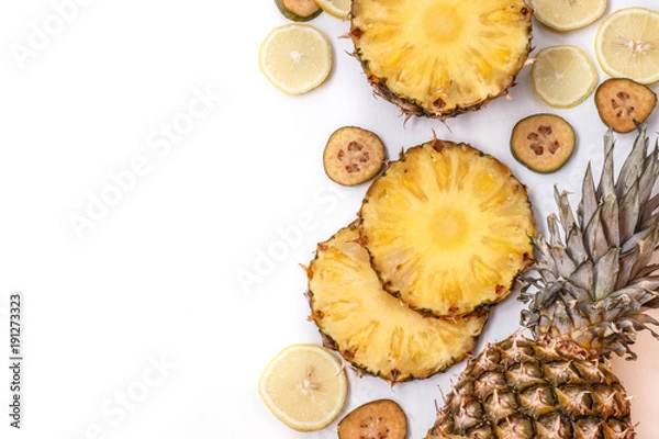 Fototapeta slices of pineapple, feijoa and lemon on a white background
