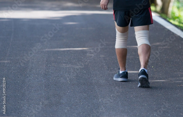 Fototapeta Close up of knee support brace on leg at public park