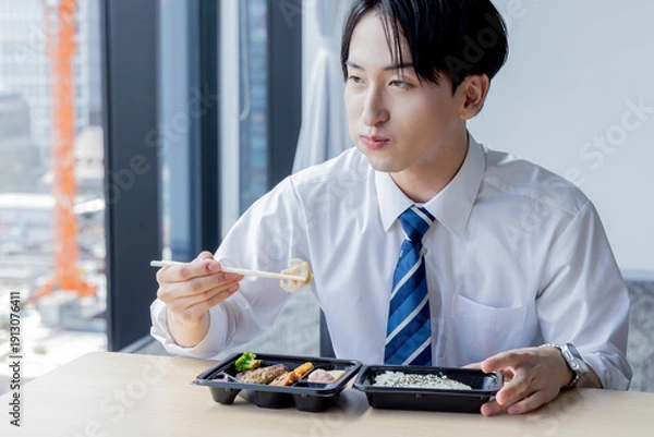 Obraz 会議室でお弁当を食べるビジネスマン
