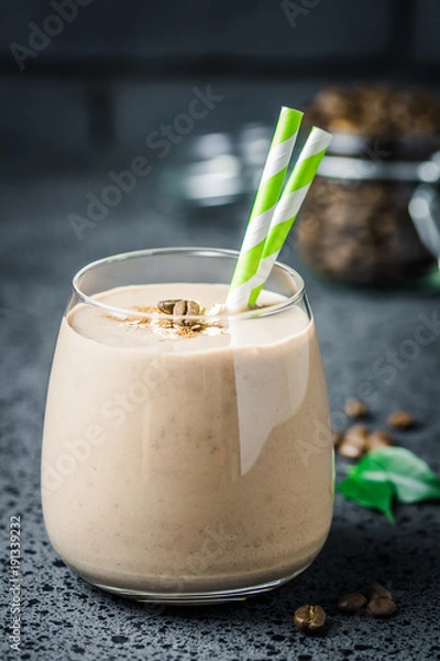 Fototapeta Coffee peanut butter protein smoothie and coffee beans in glass jar on dark concrete background. Selective focus, space for text. 