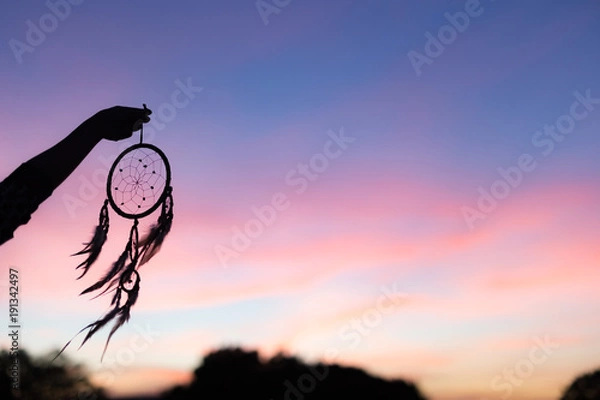 Obraz Silhouette of Dream Catchers hold up in the air during sunset period